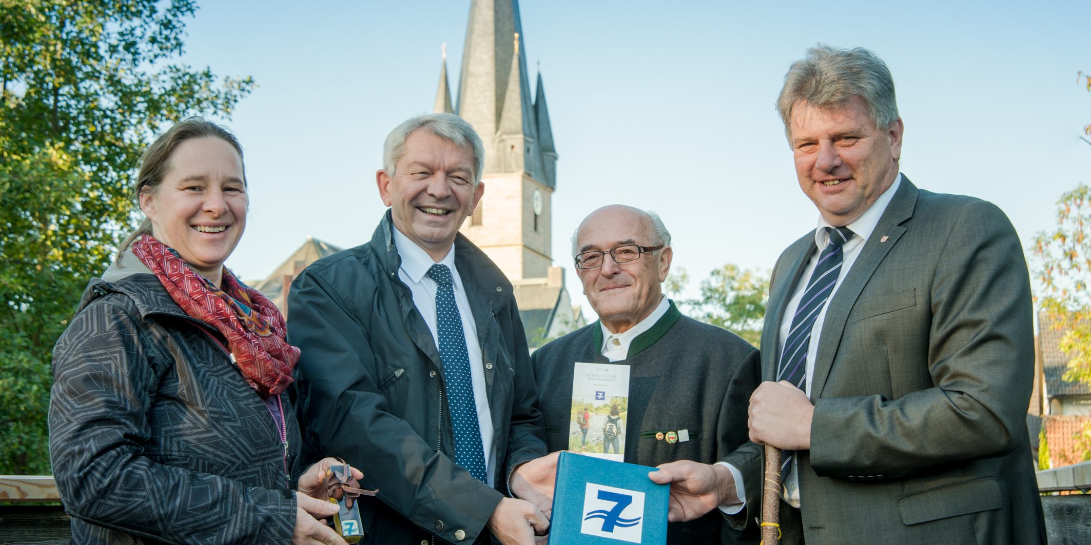 Landrat Johann Kalb übergibt das Wanderbuch zum Sieben-Flüsse-Wanderweg in Baunach. Foto: Thomas Ochs.