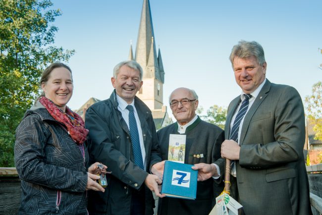 Landrat Johann Kalb übergibt das Wanderbuch zum Sieben-Flüsse-Wanderweg in Baunach. Foto: Thomas Ochs.