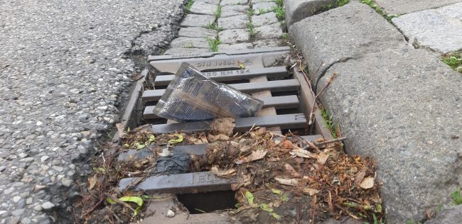 Eine leere Getränkeverpackung ist im Rinnstein in einen Gully gespült worden. Foto: Anne Schmitt / Flussparadies Franken
